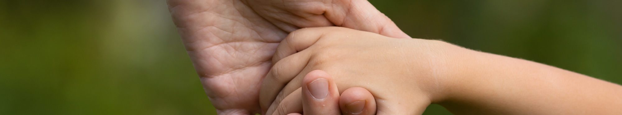 Hand eines Erwachsenen hält die Hand eines Kindes